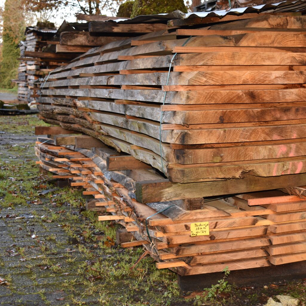 Grote stapel kastanjebovenplaten buiten op het landgoed van Hard- en Zachthout, perfect voor buitenprojecten en meubelbouw