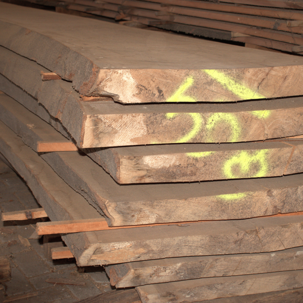 Close-up van een stapel ongestoomd beukenhout, met zichtbare nerfstructuur, perfect voor meubelmakerij en timmerwerk.